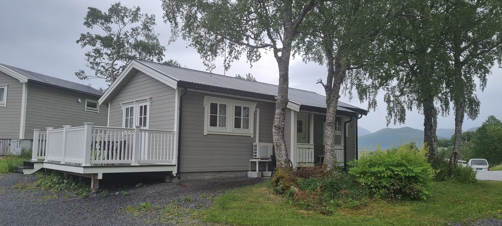 Cabin 1 from outside, in the row with its deck and birch trees