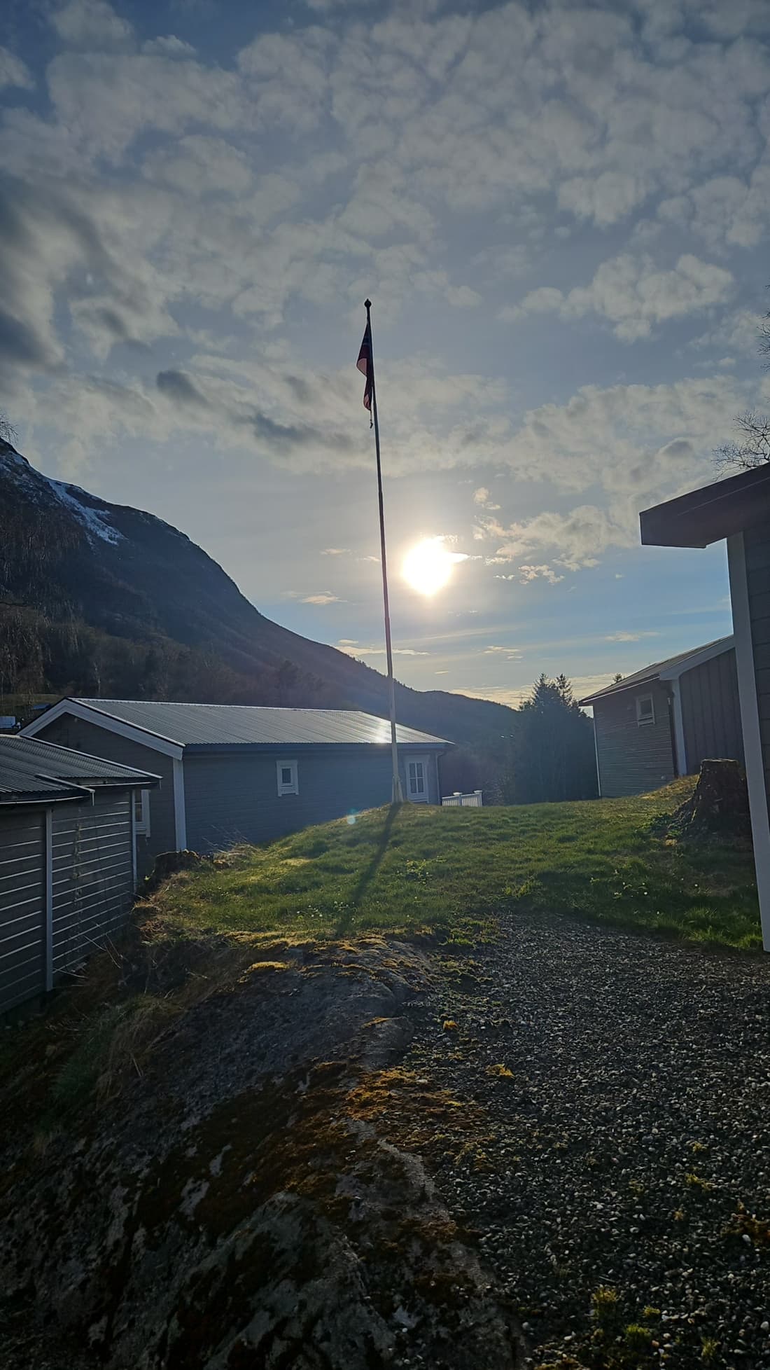 Cabin 3 in evening light, with the flagpole and the mountain behind