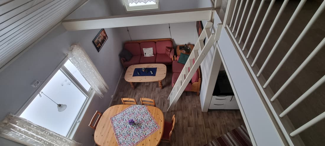 Blick von der Empore hinunter in den Wohnraum von Hütte 5