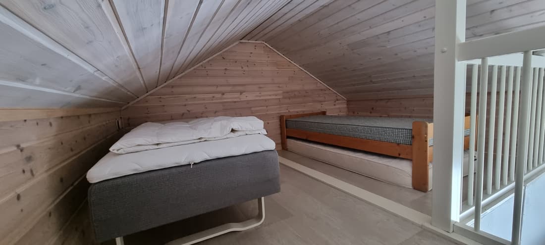 Die Empore in Hütte 5 mit Bett unter der Dachschräge