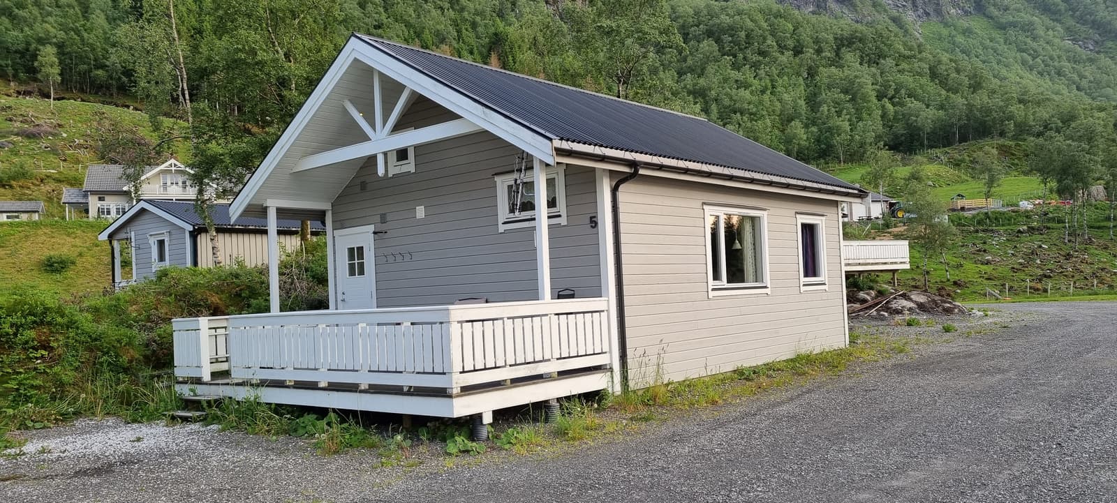 Cabin 5 from outside, with its deck and the mountainside behind