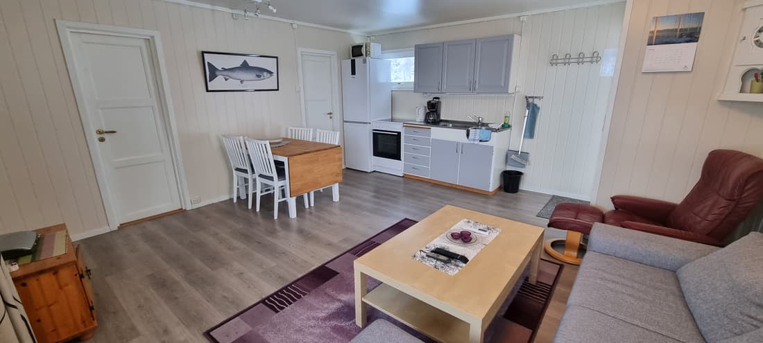 Wohnraum und Küche in Hütte 7 mit Esstisch und Sofa