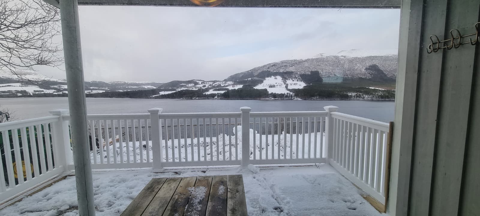 Der Blick von der Veranda der Hütte 7 über den Nåsvatnet zu verschneiten Bergen
